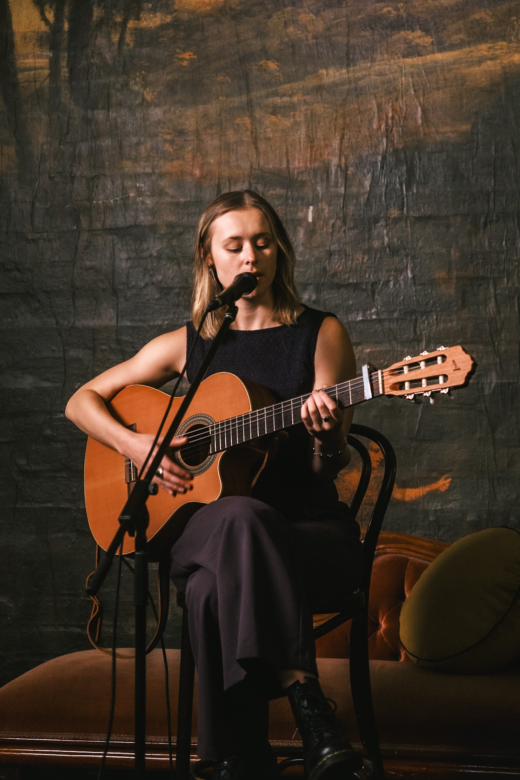 A musician performing an acoustic set at a Stage and Storytelling showcase
